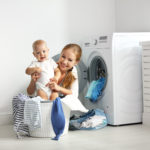 Elektroinstallation Grundlagen Legende, Schaltzeichen, Schaltplan, Ratgeber, mother a housewife with a baby engaged in laundry fold clothes into the washing machine